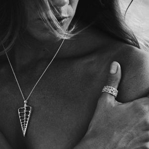 woman wearing ocean inspired handmade cerithium shell pendant made in Australia in sterling silver on bare skin