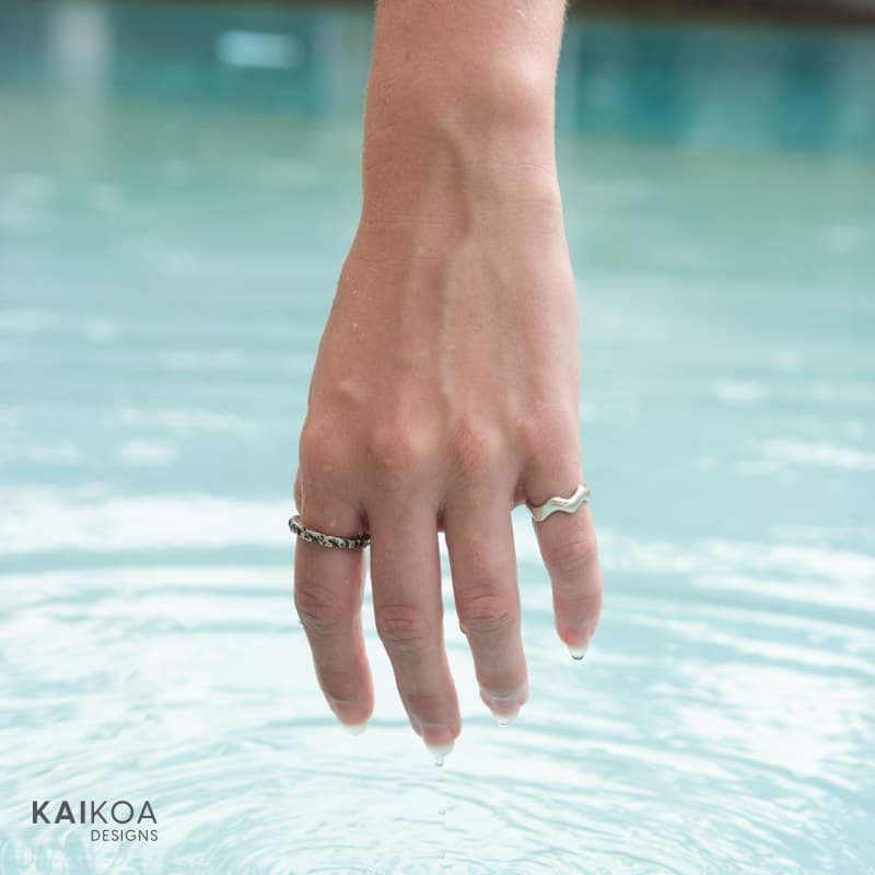 10 things to consider when buying Australian made jewellery - Kaikoa Designs Handmade sterling silver ring on a finger made in Australia with the shape of a wave