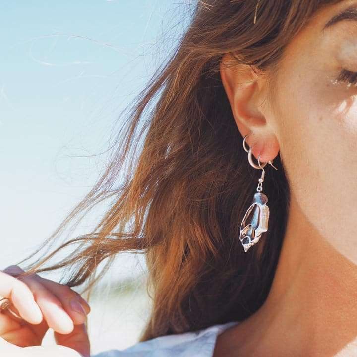 10 things to consider when buying Australian made jewellery - Kaikoa Designs Blonde woman wearing ocean beach inspired sea shell shaped silver earrings made in Australia