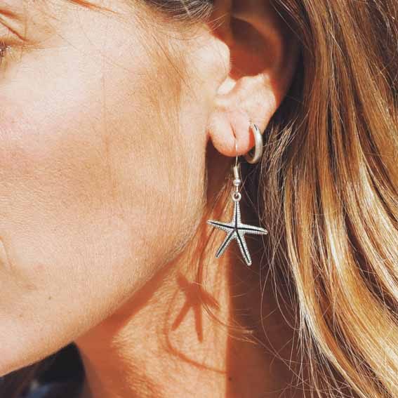 10 things to consider when buying Australian made jewellery - Kaikoa Designs Blonde woman with white top wearing sea shell shaped earrings made out of sterling silver made in Australia